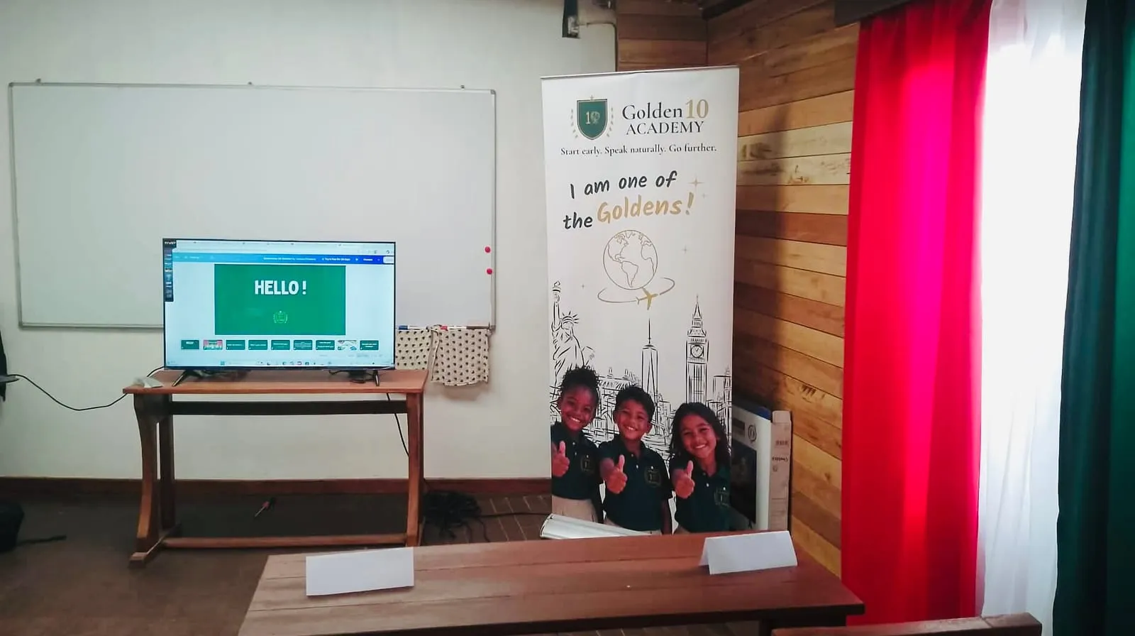 Une salle de classe de Golden 10 Academy, avec l'écran, le tableau et la bannière de l'académie
